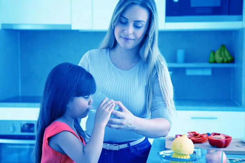 Mom giving kid glass of water